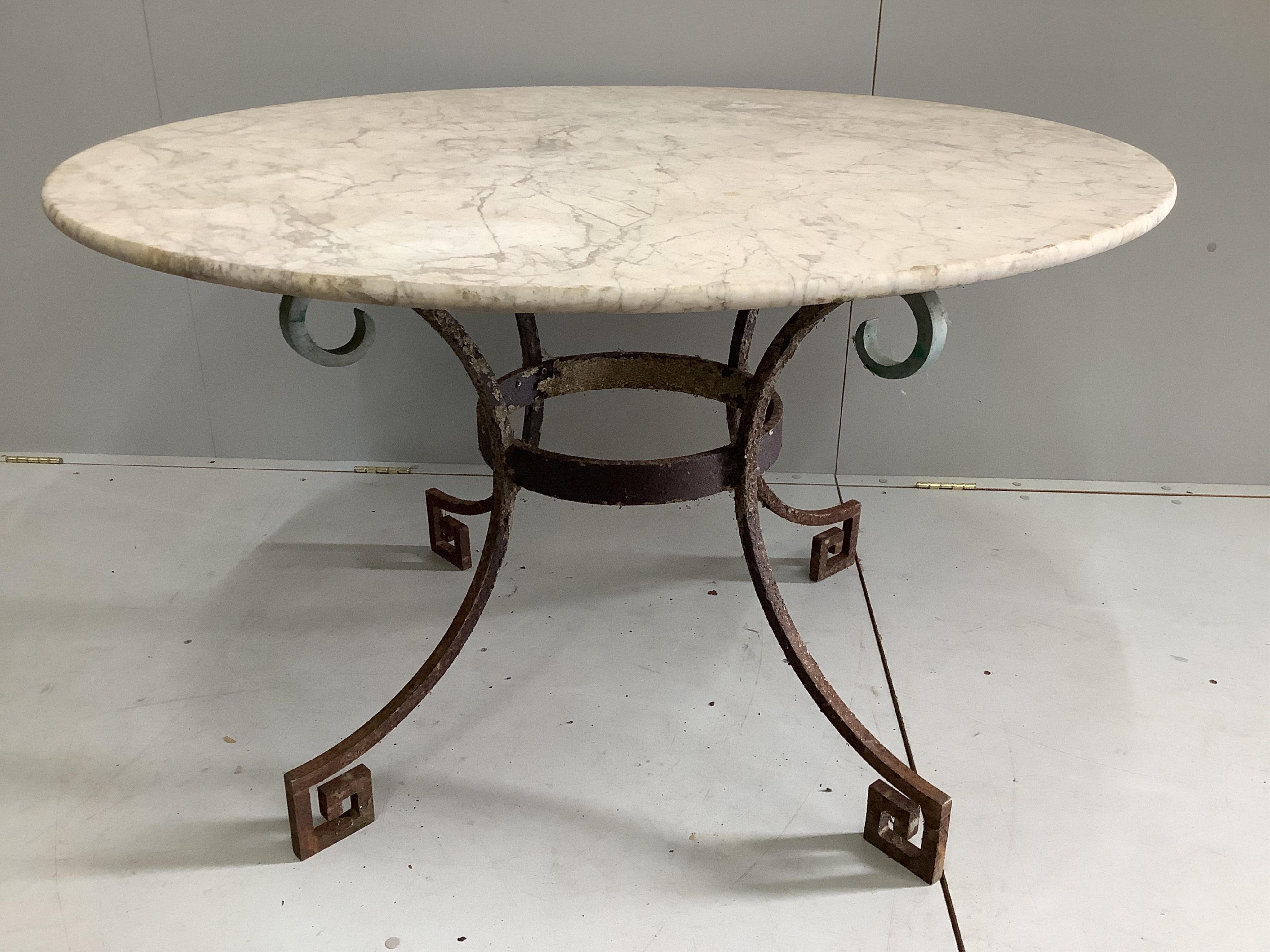 A circular wrought iron white marble topped garden table, diameter 120cm, height 73cm. Condition - good